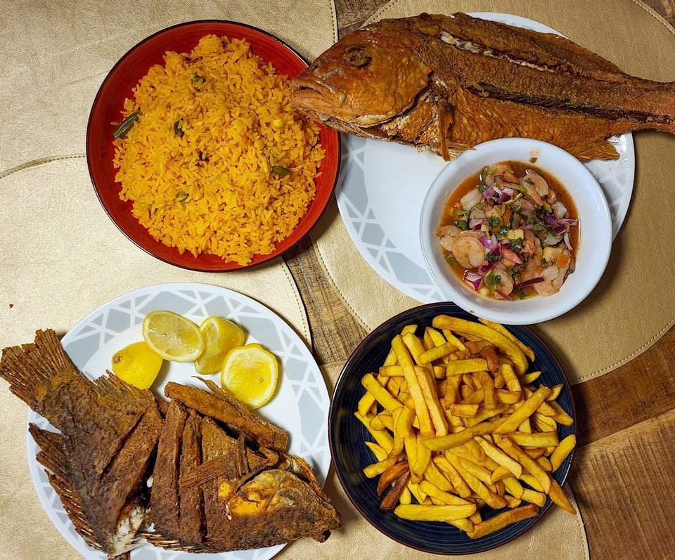 Fresh fish with rice and fried sides.